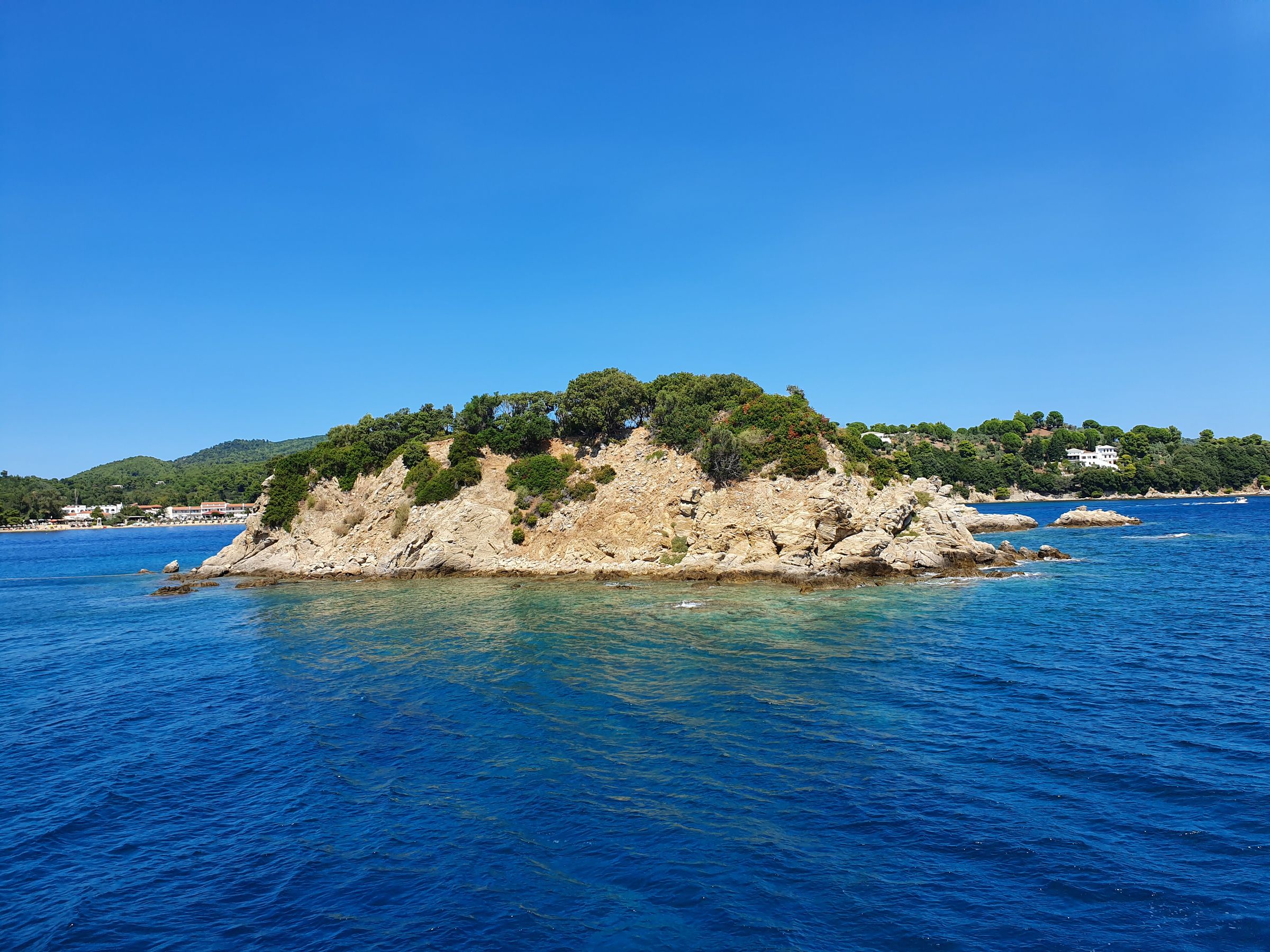Rocky uninhabited island covered in green vegetation in the Sporades marine park, Greece