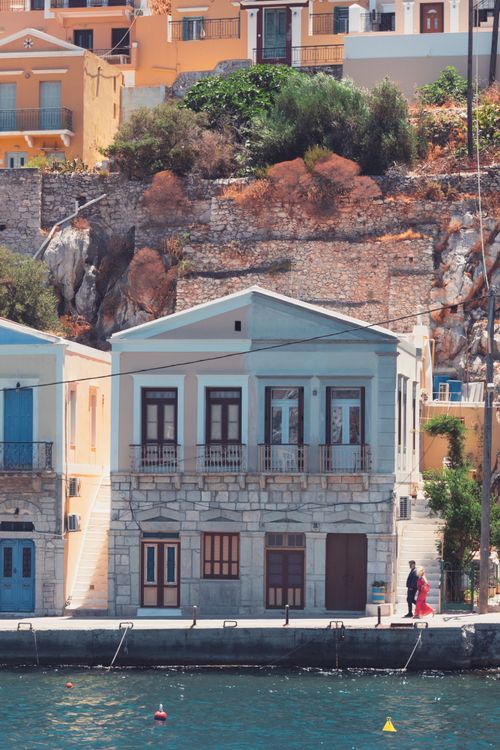 Traditional neoclassical houses with colourful facades along the harbour of Ano Symi, Dodecanese, Greece