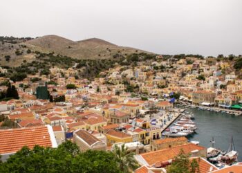 Aerial view of Symi island harbour with colourful neoclassical houses rising up the hillside, Dodecanese, Greece