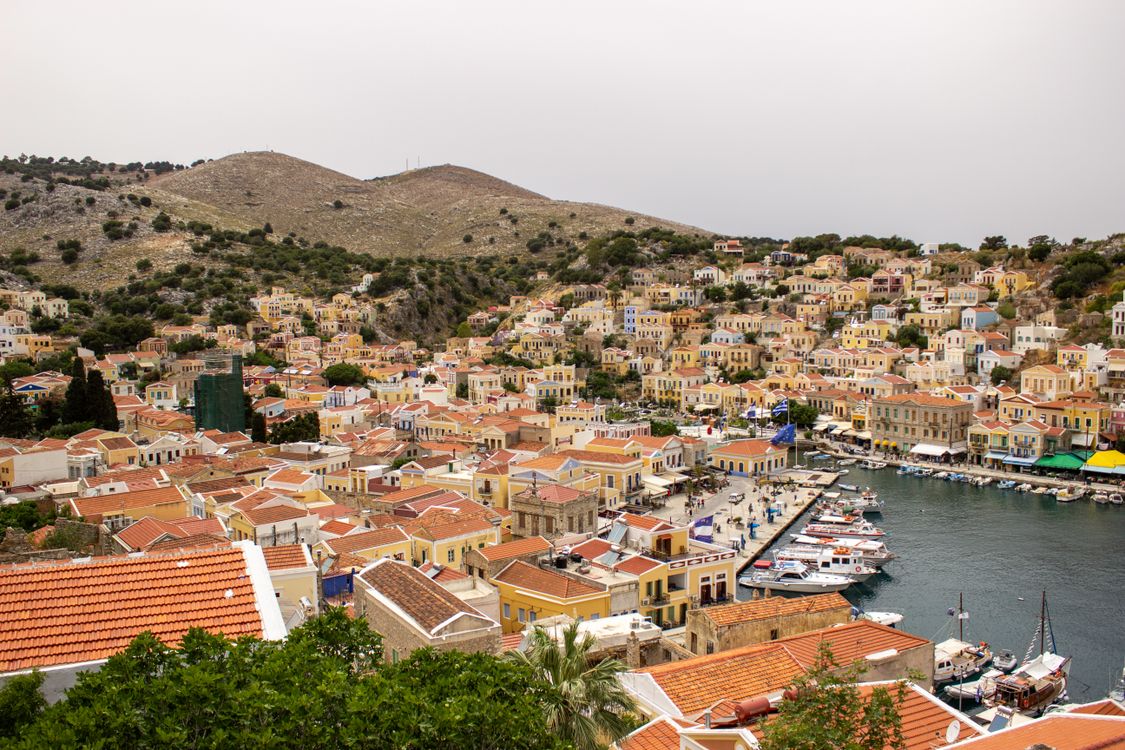 Aerial view of Symi island harbour with colourful neoclassical houses rising up the hillside, Dodecanese, Greece