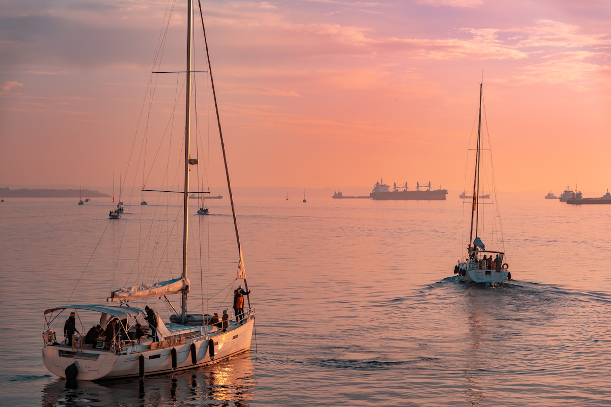 Sailboats moored in Thessaloniki port with the city waterfront and evening light behind them