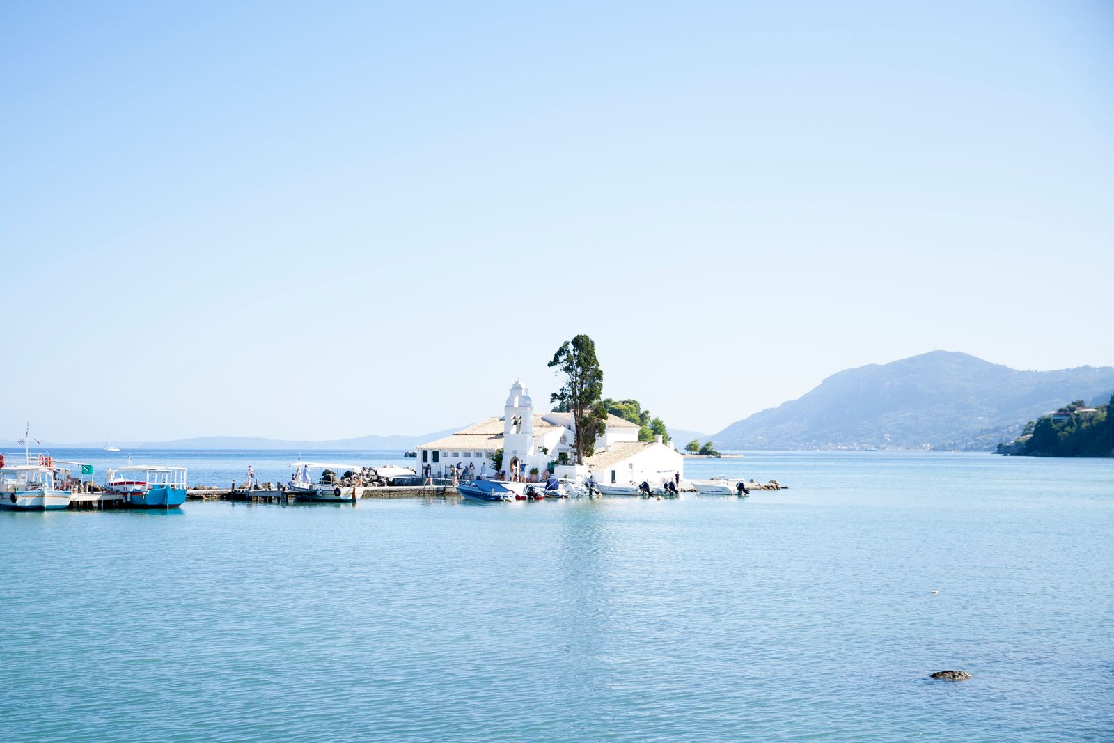 Vlacherna Monastery on its narrow causeway with Pontikonisi Mouse Island behind it in Corfu, Greece