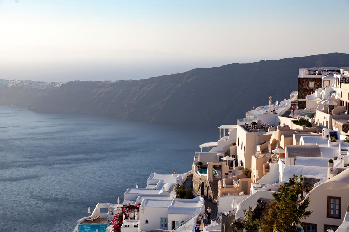 Imerovigli cliffside buildings carved into the caldera rock face in Santorini