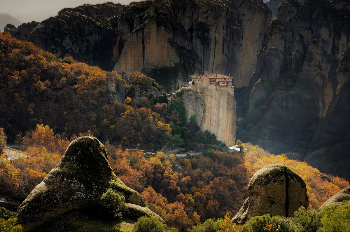 Meteora Monastery perched on rocky cliffs amid autumn foliage in Kalabaka, Greece